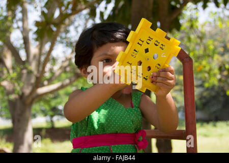 Ein Kind spielt mit Spieluhr, Pune, Indien Stockfoto