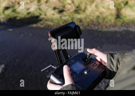 Mann außerhalb der Kontrolle Drohne vom Handy oder Tablet Bildschirm Stockfoto