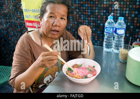 Thai-Küche. Alte Frau Rosa Nudeln essen. Markt Stall und Street Essen in Chinatown Bangkok, Thailand vorbereitet. Yaowarat, Stockfoto