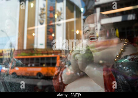 Reflexion eines Buddha in einem Geschäft. Bangkoks Chinatown, Thailand. Markt-Stall und Street Essen in Chinatown für vorbereitet Stockfoto