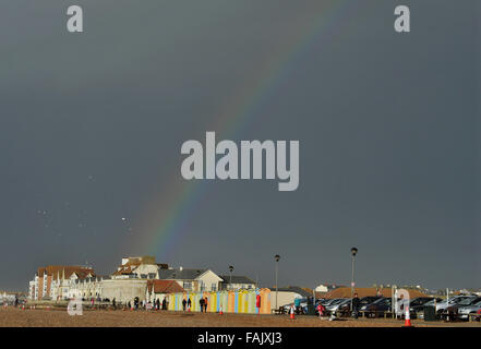 Seaford Sussex 31. Dezember 2015 - ein Regenbogen leuchtet dunkle Gewitterwolken über Strandhütten entlang Seaford Strandpromenade heute in East Sussex als das Ende des Sturms Frank Großbritannien Kredit geht: Simon Dack/Alamy Live News Stockfoto