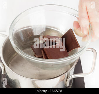 Putting Schüssel mit Schokolade über Topf mit Wasser zum Schmelzen als Bain Marie Stockfoto