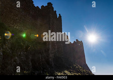 Eine tiefstehende Sonne strahlt über der Wand des verlassenen alten Schloss in der spanischen Landschaft. Stockfoto