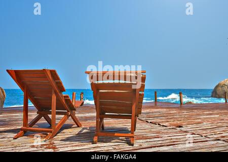 Sonnenliegen auf einer Holzbrücke im Meer Stockfoto