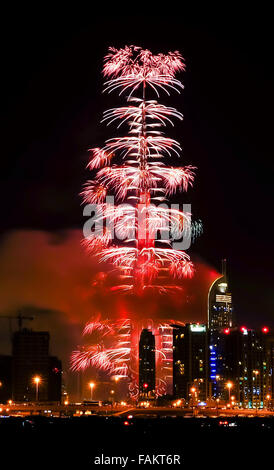 Dubai, Vereinigte Arabische Emirate. 31. Dezember 2015. Feuerwerk explodieren als Rauch Wogen vom nahe gelegenen Adresse Downtown Hotel, das auf Feuer Stunden früher, in der Nähe des Burj Khalifa, dem höchsten Turm der Welt in Dubai, Vereinigte Arabische Emirate, am 31. Dezember 2015 gefangen. Feuer brach am Donnerstag in einem luxuriösen Hotel in Dubai, wo Menschen in der Nähe versammelten, um Silvester Feuerwerk zeigen zu sehen. Bildnachweis: Zhang Shumin/Xinhua/Alamy Live-Nachrichten Stockfoto