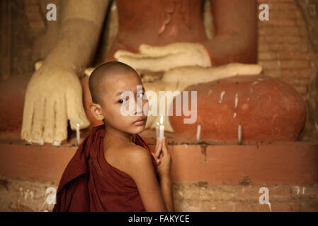 Porträt der junge Novize mit Kerzenlicht in einem buddhistischen Tempel, Bagan, Myanmar zu beten. Stockfoto