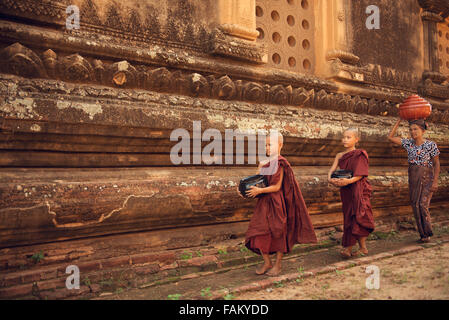 Southeast Asian junge Anfänger Mönche wandern Morgen Almosen in Old Bagan, Myanmar Stockfoto