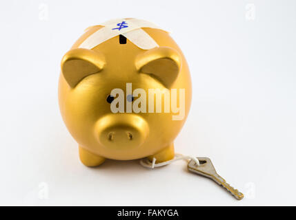 Piggy Bank in gold Farbe ist auf dem Rücken gesperrt. Die Taste gedrückt halten auf dem Bein. Sie sind auf einem isolierten Hintergrund. Stockfoto