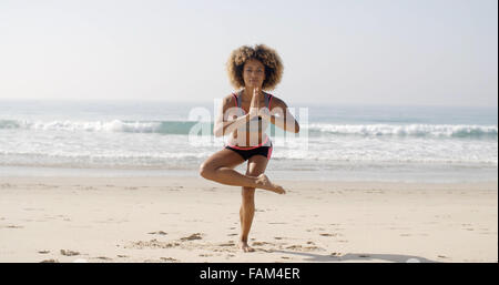 Frau tut Yoga am Strand Stockfoto
