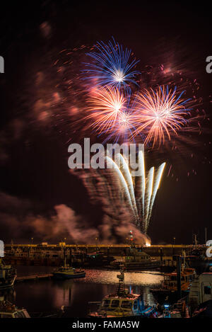 Neujahr Silvester Feuerwerk in Ramsgate Royal Harbour mit der Handelsflotte im Vordergrund. Stockfoto