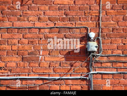 Elektrokabel-Installation an alten roten Ziegel-Wand montiert Stockfoto