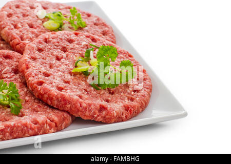 Rohen Hamburger Scheiben auf weißen Teller isoliert, Nahaufnahme Stockfoto