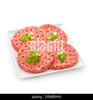 Vier Scheiben von rohen Hamburger auf weißen Teller isoliert Stockfoto