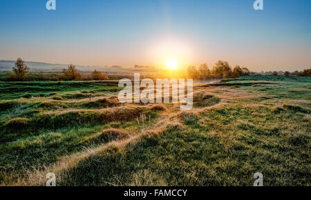 Frostiger Morgen Sonnenaufgang über dem Fluss und einem Feld Stockfoto