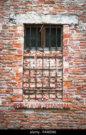 Alte Fenster von einem verlassenen Haus mit Ziegeln geschlossen. Stockfoto