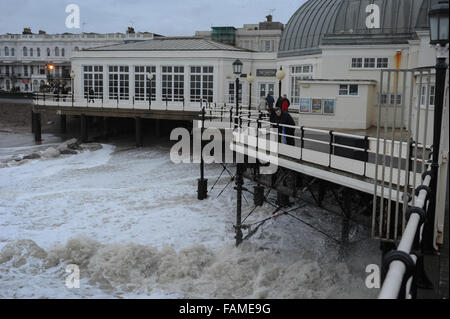 Menschen auf Worthing Pier stehen und beobachten Sie die großen Wellen auf den Strand am Neujahrstag in Worthing, West Sussex, England. Stockfoto