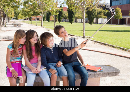 Schule Kinder sprechende Fotos mit einem Selfie-stick Stockfoto