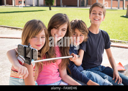 Schule Kinder sprechende Fotos mit einem Selfie-stick Stockfoto