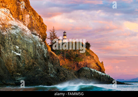 Das letzte Licht des Tages beleuchtet die brechenden Wellen, Klippen und Leuchtturm am Cape Enttäuschung. Stockfoto