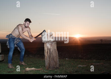 Die stilvolle Holzfäller Holzhacken bei Sonnenuntergang. Stockfoto