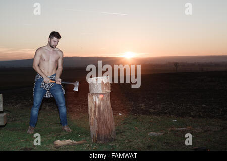 Die stilvolle Holzfäller Holzhacken bei Sonnenuntergang. Stockfoto