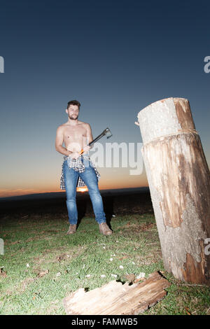 Die stilvolle Holzfäller Holzhacken bei Sonnenuntergang. Stockfoto