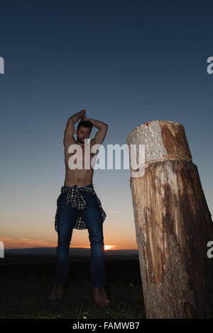 Die stilvolle Holzfäller Holzhacken bei Sonnenuntergang. Stockfoto