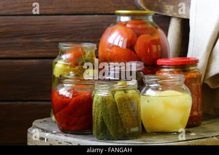 Obst und Gemüse in Gläsern auf einem Holzstuhl Stockfoto