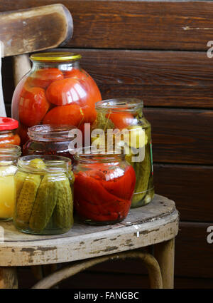 Obst und Gemüse in Gläsern auf einem Holzstuhl Stockfoto
