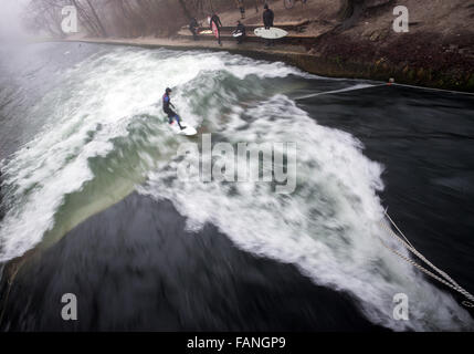 München, Deutschland. 1. Januar 2016. Eine Surfer reitet eine Welle am Eisbach Creek im englischen Garten in München, 1. Januar 2016. Foto: PETER KNEFFEL/Dpa/Alamy Live News Stockfoto