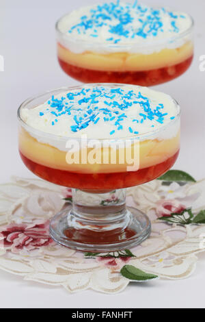 Traditionellen Erdbeer Trifle Dessert mit frischer Schlagsahne Sahne und blauen Zucker Streusel Stockfoto