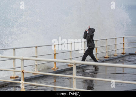 Aberystwyth, Wales, UK. 2. Januar 2016. UK-Wetter: Trotz einer Flaute in den jüngsten stürmischen Wetter erzeugt ein erheblicher Wellengang dramatische Wellen gegen die Promenade. Hier ist ein kleiner Junge gesehen die Wellen ausweichen. Bildnachweis: Alan Hale/Alamy Live-Nachrichten Stockfoto