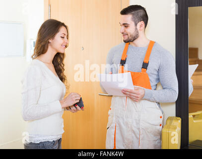 Lächelnde Hausfrau treffen Service Arbeitnehmer an der Tür zu Hause Stockfoto
