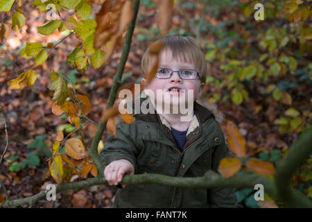 Ein spectacled Jungen spielen im Wald, Worcestershire, UK. Stockfoto