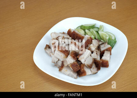 Schüssel mit knusprigem Schweinefleisch auf Holztisch Stockfoto