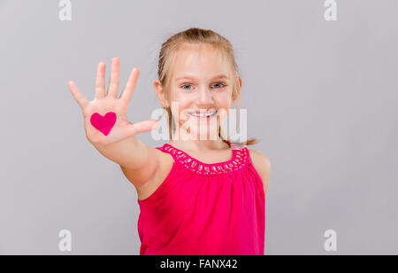 Niedliche Mädchen mit rosa Herzen am Valentinstag lächelnd. Stockfoto