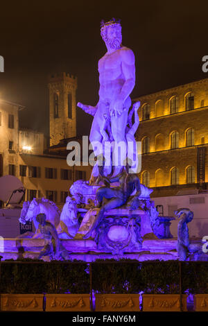 Neptun-Brunnen auf der Piazza della Signoria nachts hinter historischen Gebäuden und Turm, Florenz, Toskana, Italien Stockfoto