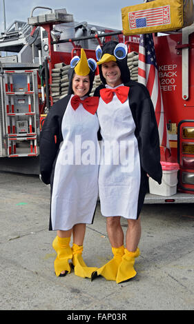 Ein paar gekleidet wie Pinguine vor einem Feuer-LKW in der Nähe der Promenade auf Coney Island, Brooklyn, New York darstellen Stockfoto