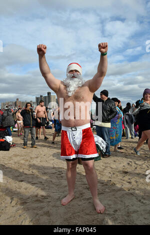Ein Mann in eine partielle Weihnachtsmannkostüm am Strand von Coney Island, Brooklyn am Silvester-Tag für die jährliche Swim-Polar Bear Club. Stockfoto