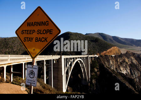 Ein Warnschild mit Blick auf die Bixby Bridge, Big Sur, Pacific Coast Highway, Kalifornien Stockfoto