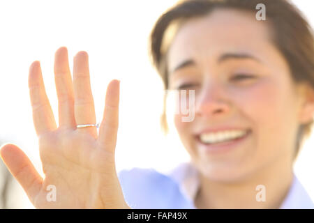 Glückliche Frau sucht einen Verlobungsring nach Vorschlag an einem sonnigen Tag Stockfoto