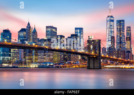 Brooklyn Bridge an und die Skyline von Lower Manhattan unter einem lila Sonnenuntergang