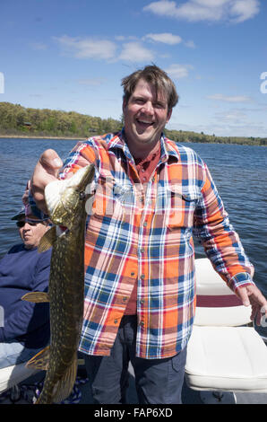 Fischer, schreien vor Freude nach dem Fang einen Hecht Fisch in der Gull Lake Kette von Seen. Nisswa Minnesota MN USA Stockfoto