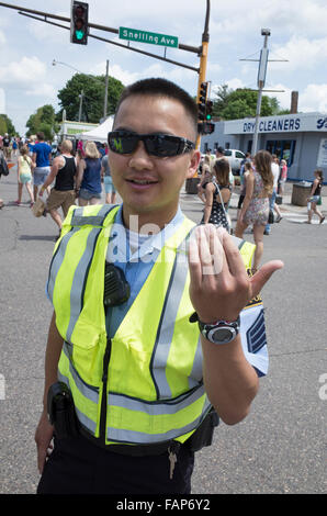 Asiatische ehrenamtliche Polizist Alter von 23 Jahren Regie Verkehr. Große alte Straße Messetage. St Paul Minnesota MN USA Stockfoto