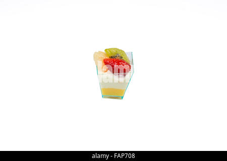 Auf dem Bild einen kleinen Kuchen mit Früchten, Sahne und Pudding im Plastikbecher, isoliert auf weißem Hintergrund. Stockfoto