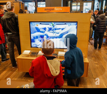 Jungs spielen Videospiel auf Feuer tv, Amazon Bücher Ziegel und Mörtel zu speichern, University Village, Seattle, Washington State, USA Stockfoto