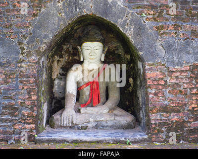 Buddha-Statue in einer kleinen Nische eine alte Stupa in Mrauk U, Rakhine-Staat in Myanmar. Stockfoto