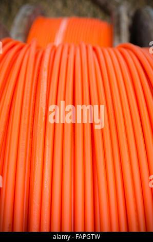Kabeltrommeln mit orange Glasfaserkabel auf einer Baustelle Stockfoto