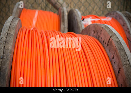 Kabeltrommeln mit orange Glasfaserkabel auf einer Baustelle Stockfoto