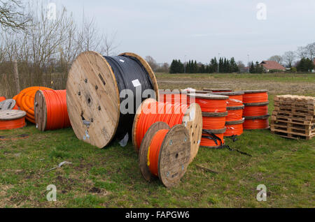 Kabeltrommeln mit orange Glasfaserkabel auf einer Baustelle Stockfoto